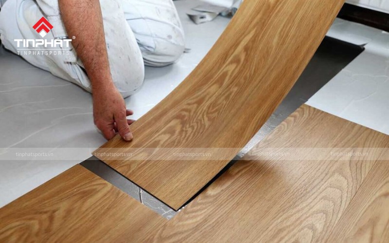 Bạn dán tấm vinyl đầu tiên từ góc tường, căn chỉnh mép tấm vinyl rồi tiếp tục dán các miếng tiếp theo